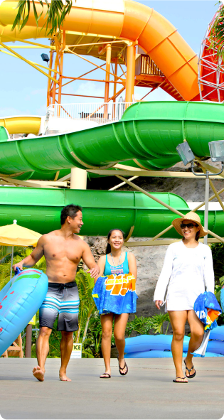 Famille marchant à côté de grands toboggans aquatiques