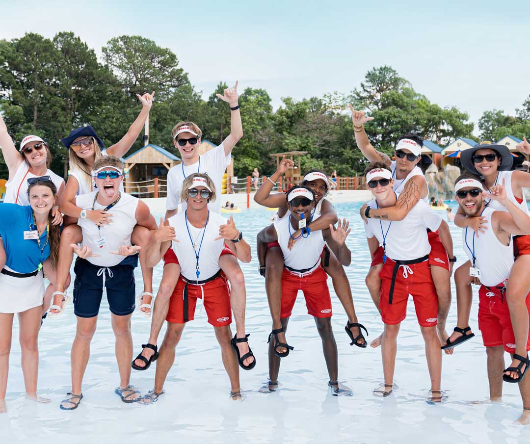 lifeguard-group-at-pool Group of lifeguards posing and having fun at wave pool